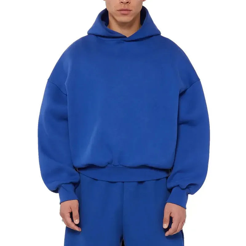 A man's grey fleece-lined cotton pullover hoodie on a hanger.