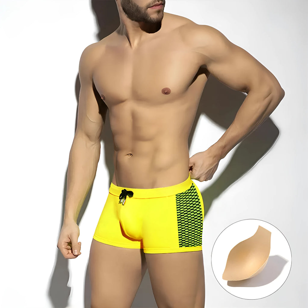 Men's black swimming boxers with white polka dot print and ribbon trim, laid flat.