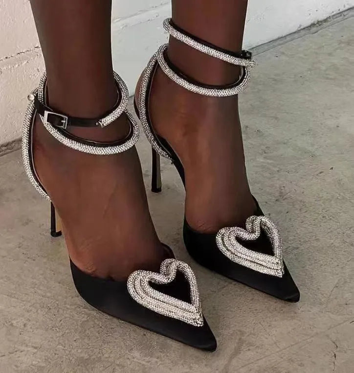 Women's pink satin sandals with pointed toe, heart-shaped rhinestones, and cross-belt ankle straps on a rubber sole.