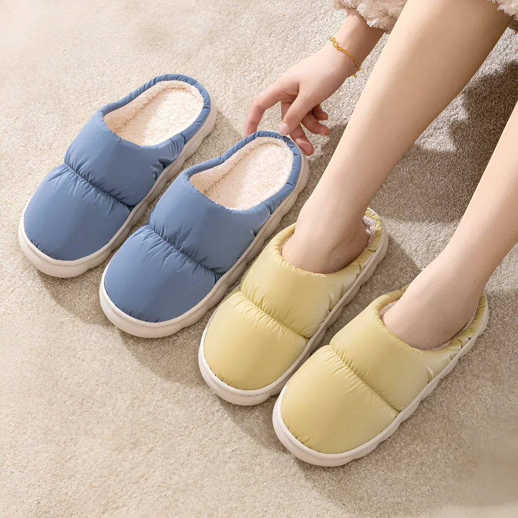 Pair of down cotton indoor slippers with artificial leather upper and thick rubber sole.