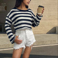 Striped long-sleeved cotton sweater with an exposed navel design on a model