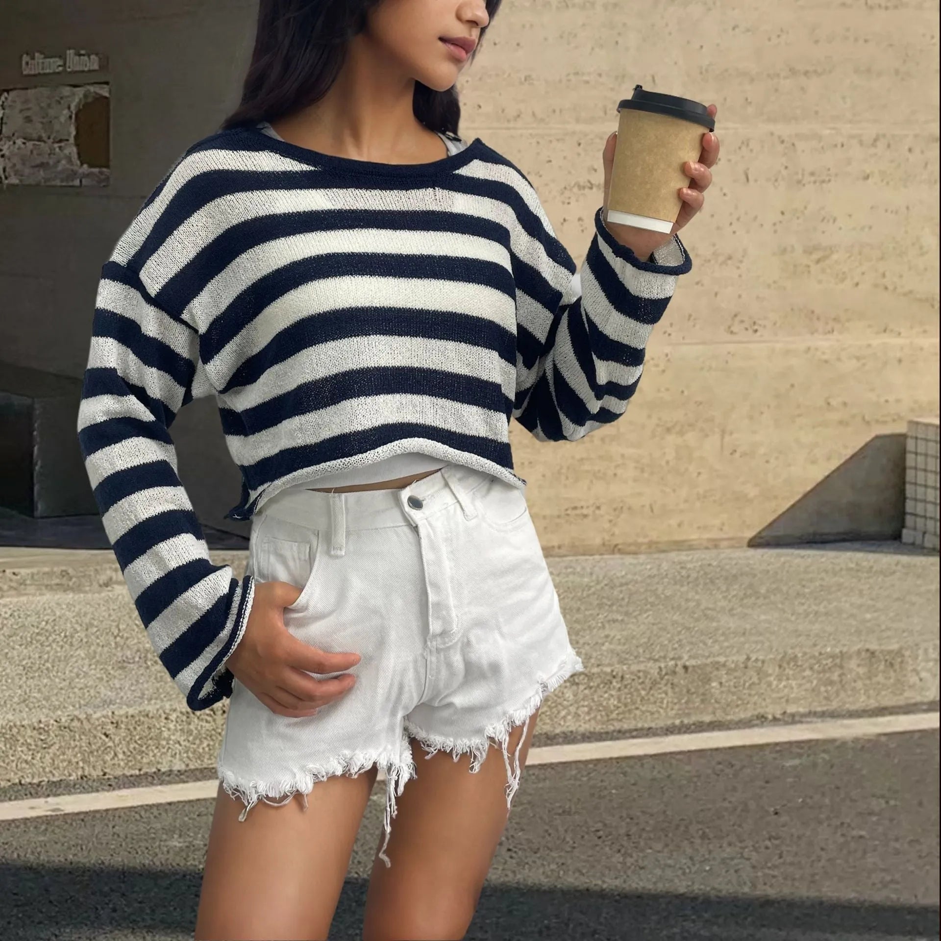 Striped long-sleeved cotton sweater with an exposed navel design on a model
