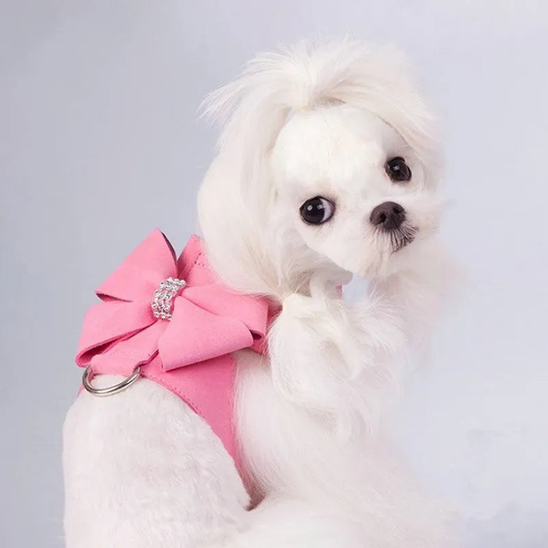 Soft pink microfiber puppy chest strap with a large white bowknot decoration laid flat.