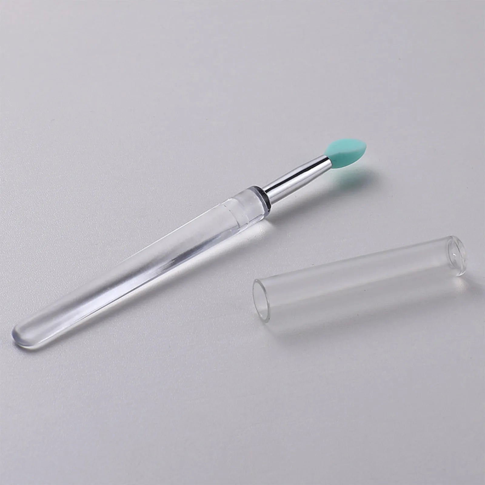 Set of reusable silicone lip brushes with protective caps in various colours.