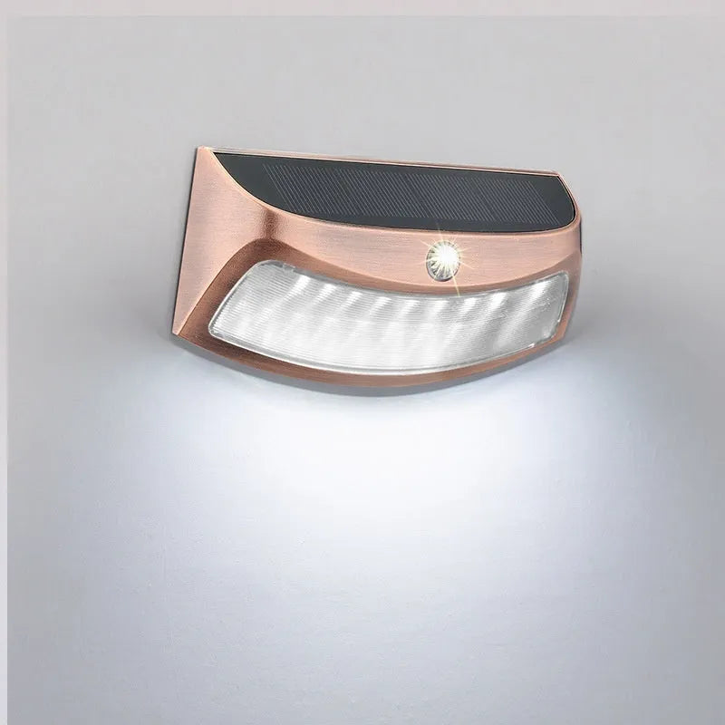 Solar-powered outdoor wall lamp with a smiling face design in warm or white light.