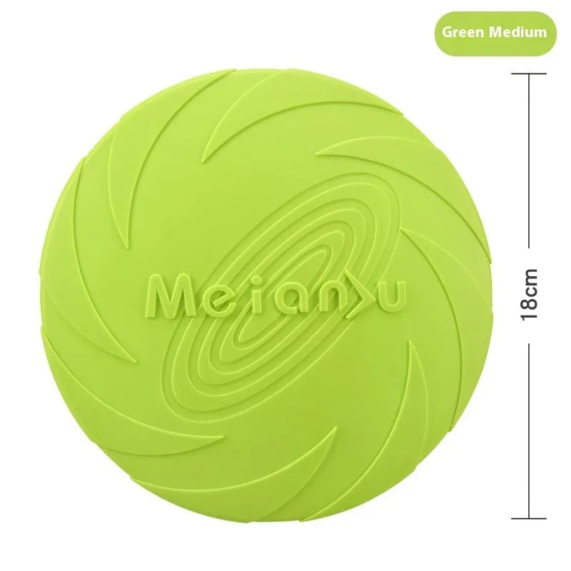 Soft rubber dog frisbee toy in blue, shown on grass for scale.