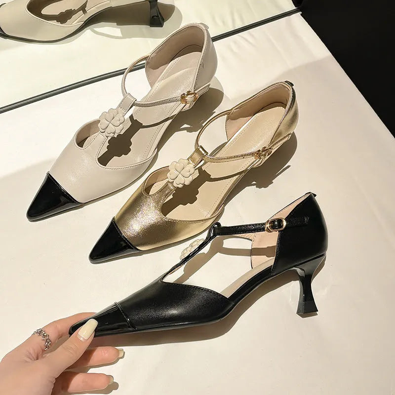 Women's black stiletto heel shoes with pointed toe, flower decoration, and buckle detail on sheepskin upper