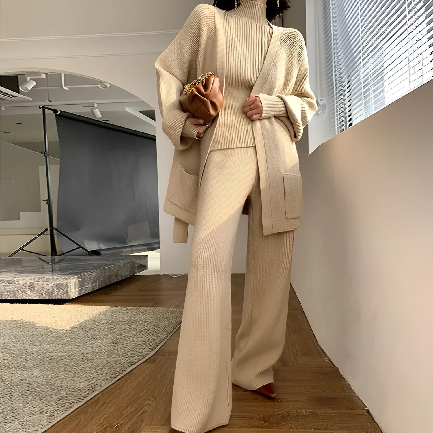 Women's knitted three-piece clothing set showing cardigan, wide-leg trousers, and top with leather stitching detail
