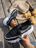 Women's Flyknit mesh sneakers in grey and white colour with flat rubber sole and lace-up front.