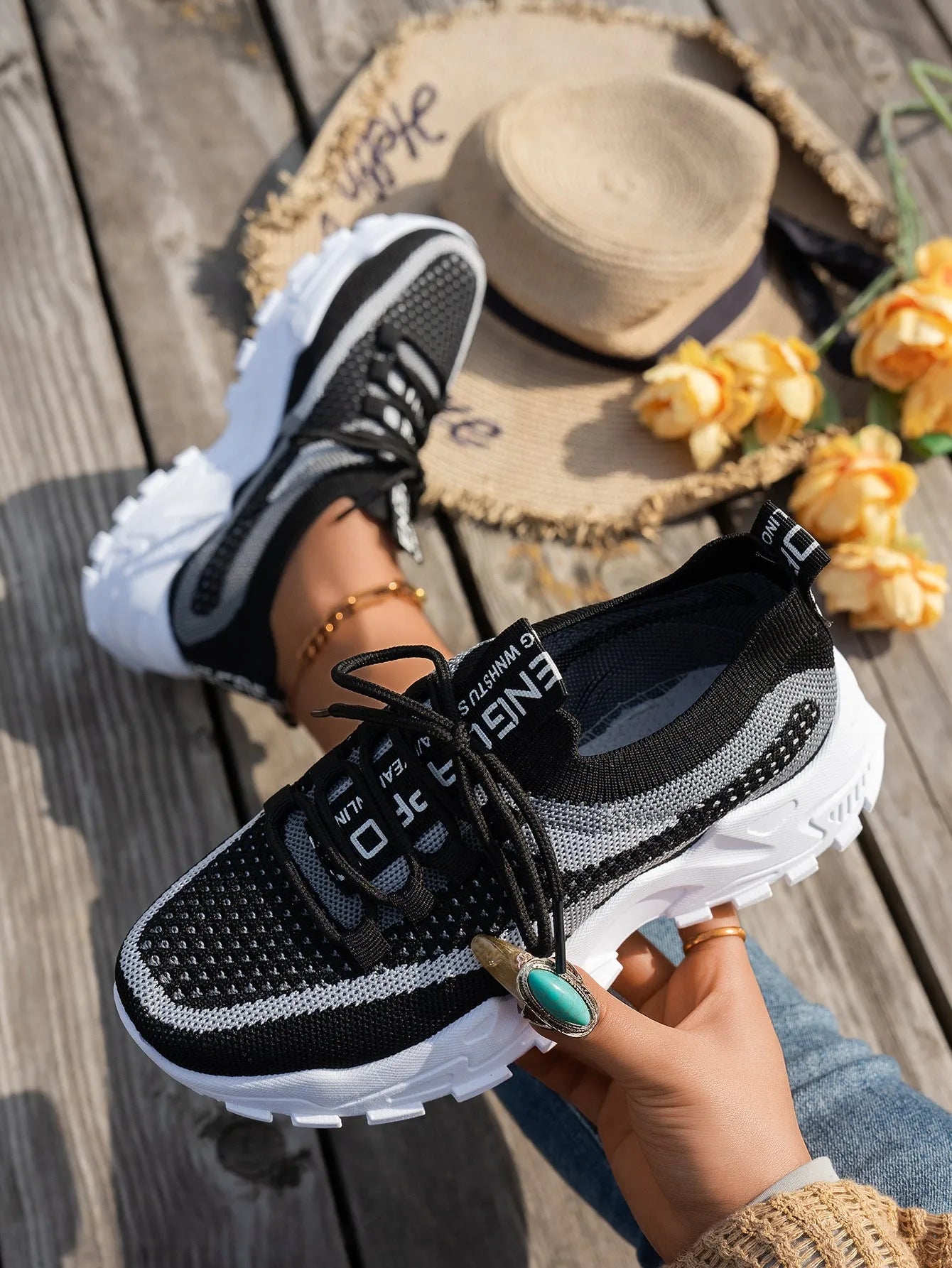 Women's Flyknit mesh sneakers in grey and white colour with flat rubber sole and lace-up front.