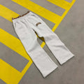 Man wearing grey patchwork loose fit hip hop trousers with a double waist design and a matching top.