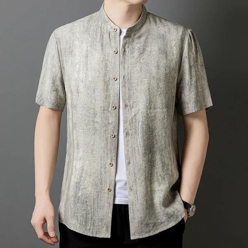 Man wearing a loose grey linen shirt with a stand collar and short sleeves, cardigan style.