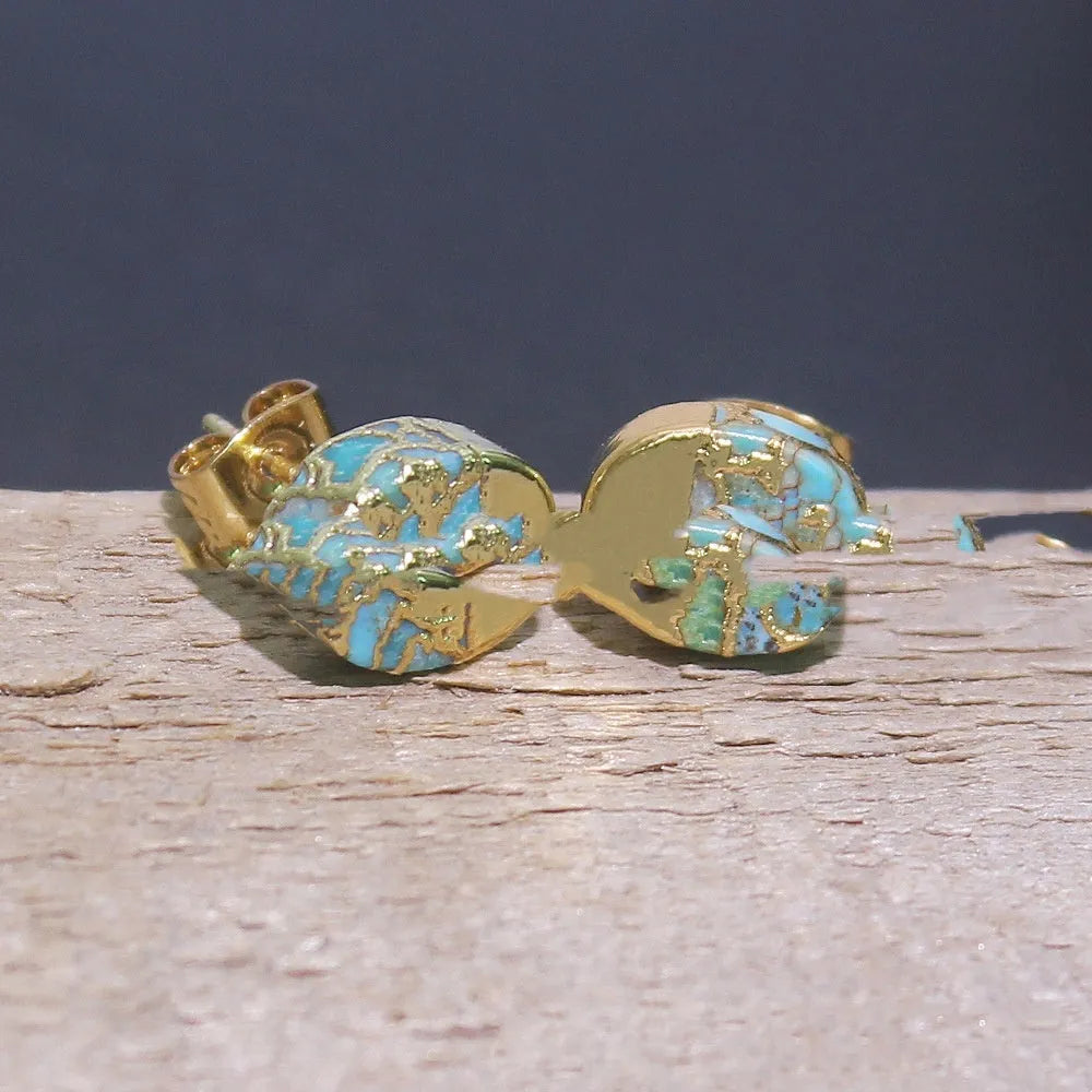 Close-up of handcrafted natural stone bohemian stud earrings with irregular shape on a plain background.