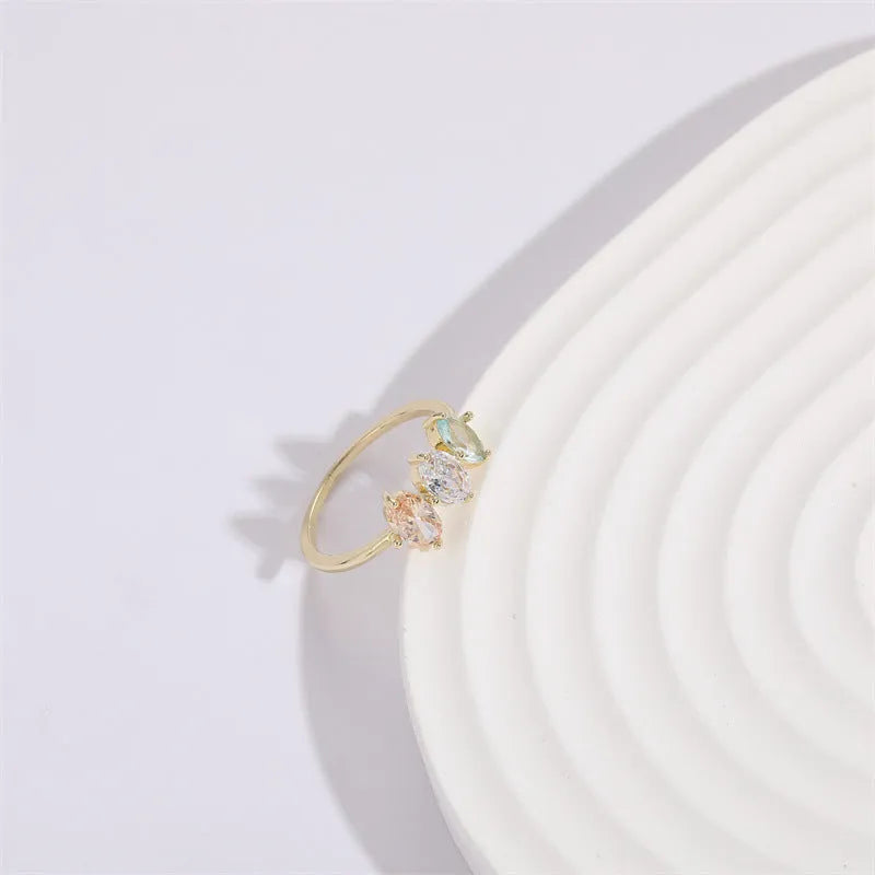 Geometric triangle birthstone ring with horse eye design and tricolour zircon stones on woman's hand