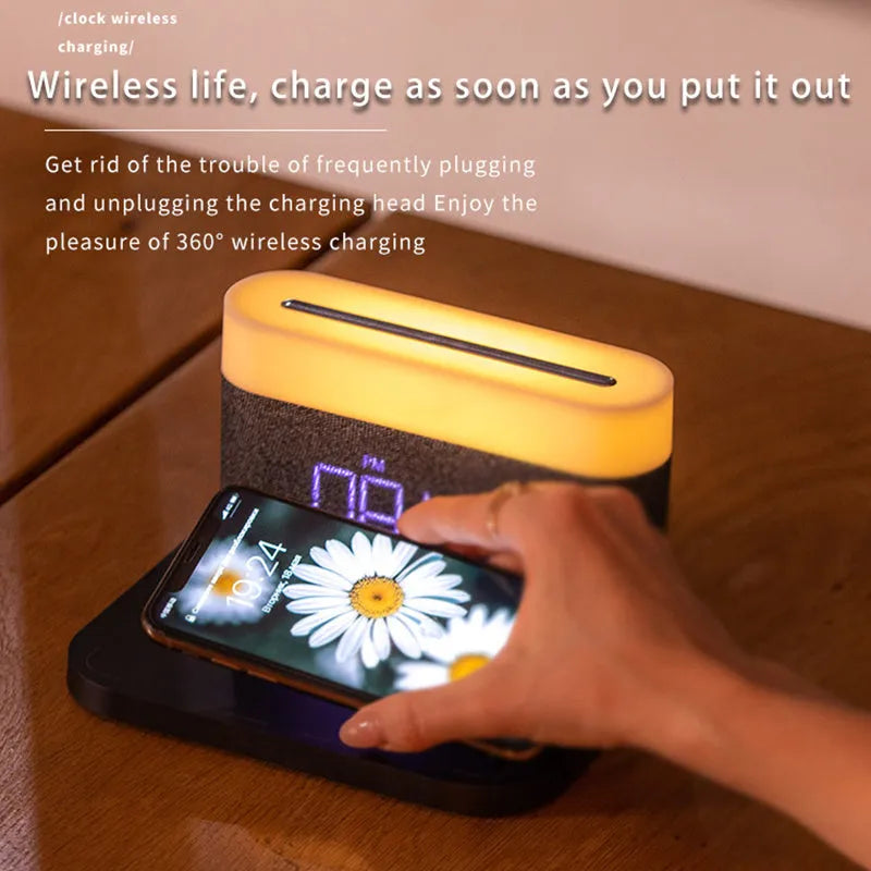 White wireless charging desktop clock with LED display and foldable stand on a wooden desk.
