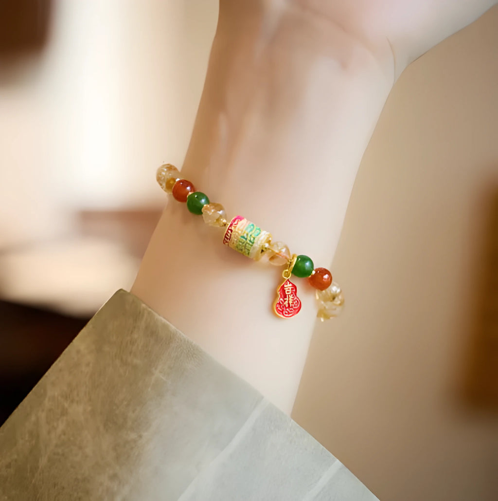 Close-up of a hand-woven citrine five sutra bracelet with 6mm geometric beads on a wrist.