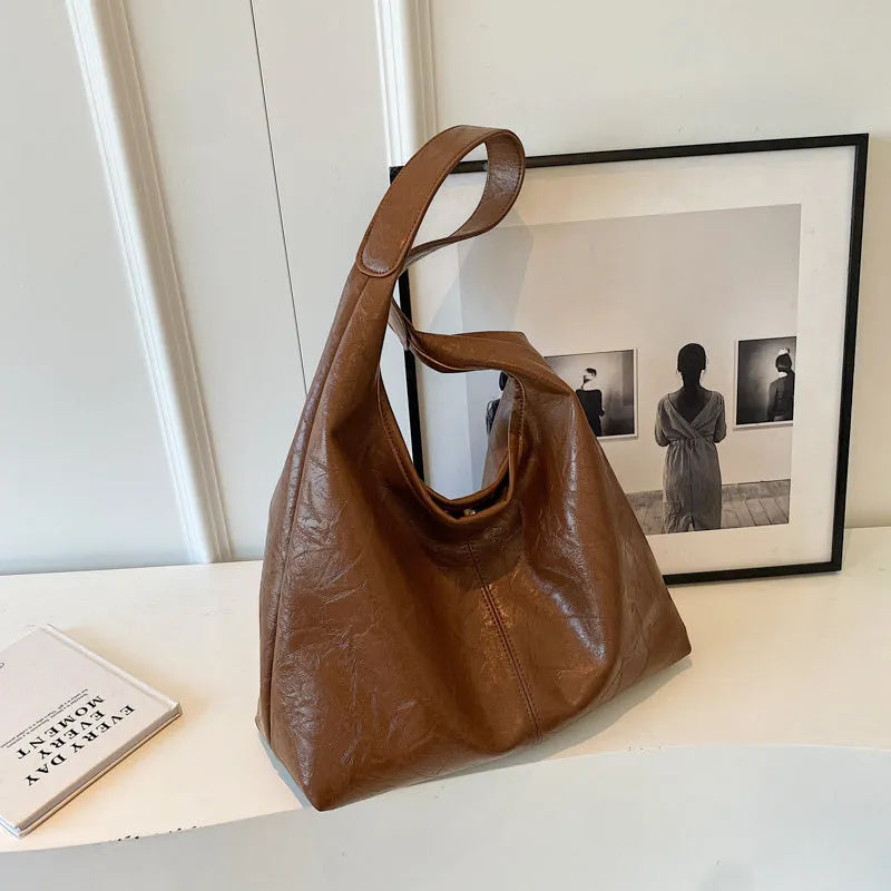 Soft leather shoulder bag in street style with sandwich pockets, shown in multiple colour options.