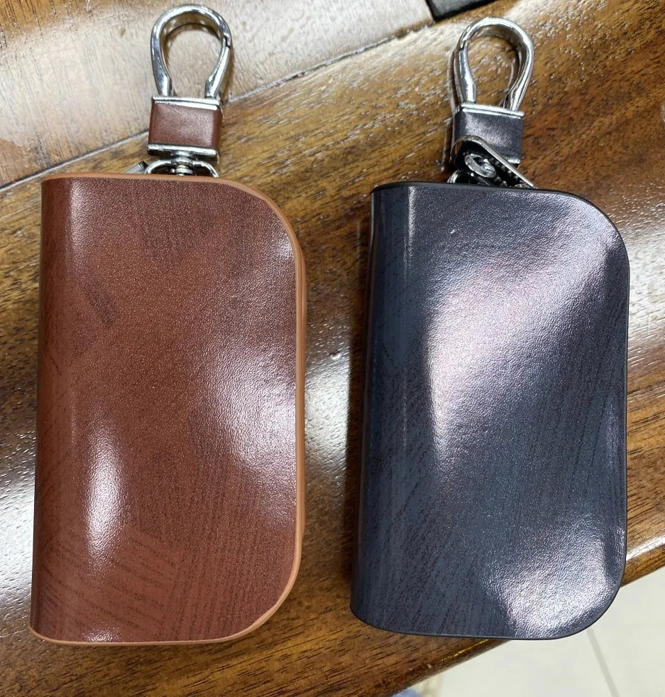 Genuine leather car key case in frost black and brown, showing soft cowhide material and size.