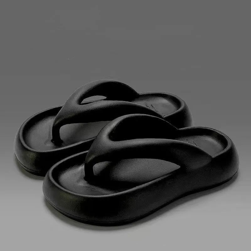 A pair of thick-soled flip-flops with a bow detail on the upper, shown in a solid colour.