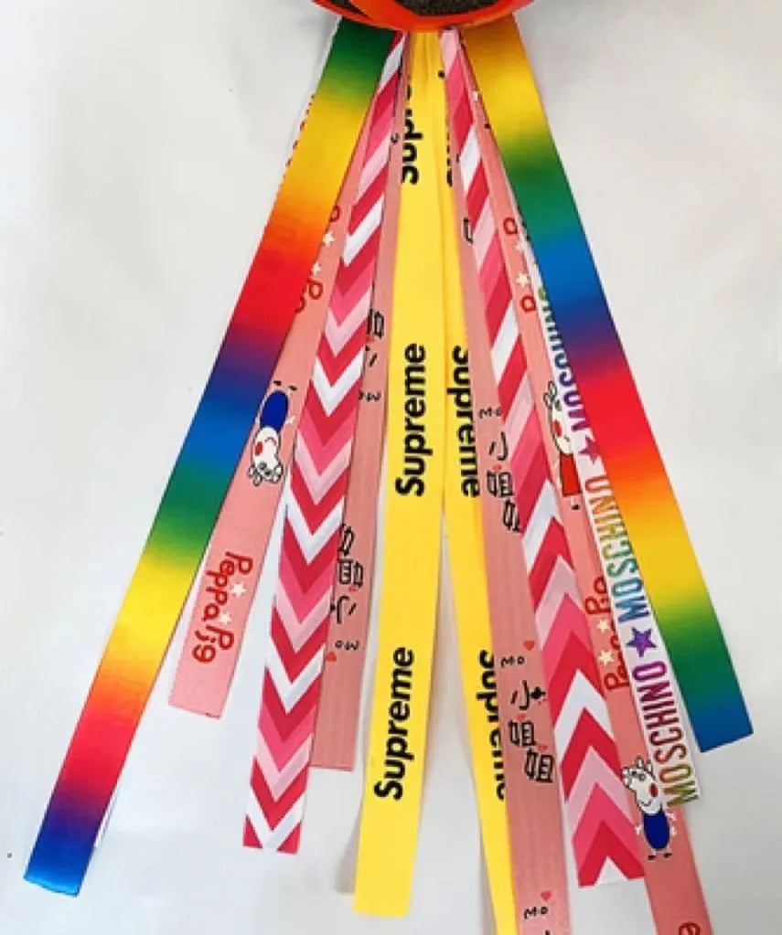 Close-up of a colourful decorative ribbon streamer attached to a child's helmet for roller skating or skiing.