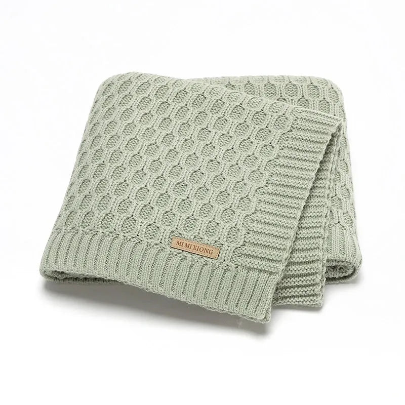 Solid colour infant hug blanket with textured lines in acrylic fabric, measuring 70 by 90 centimetres