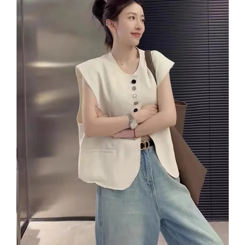 Women's loose-fit short-length polyester vest in milky white colour with front pockets.