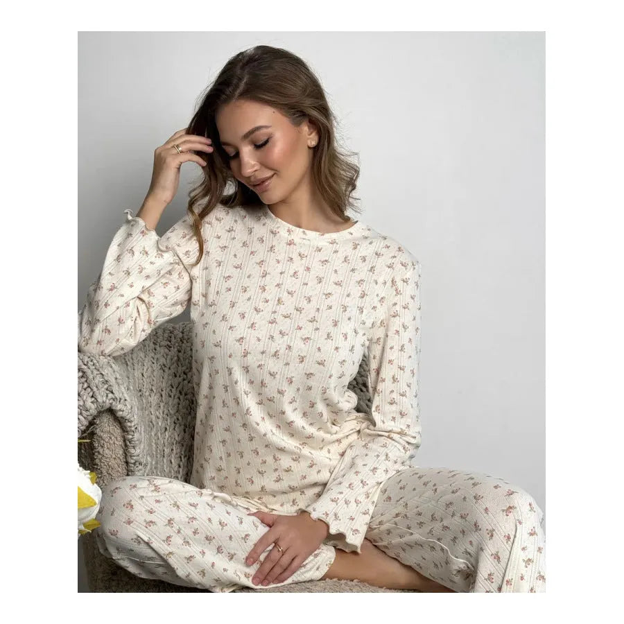 White women's floral print two-piece suit with bell sleeve top and wide leg pants on a hanger.