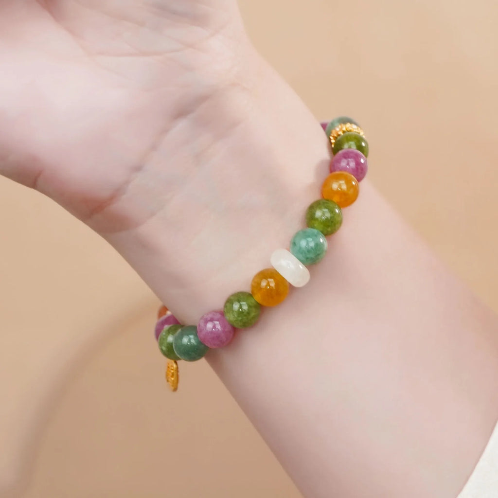Rainbow coloured electroplated tourmaline half bracelet for women on a wrist.