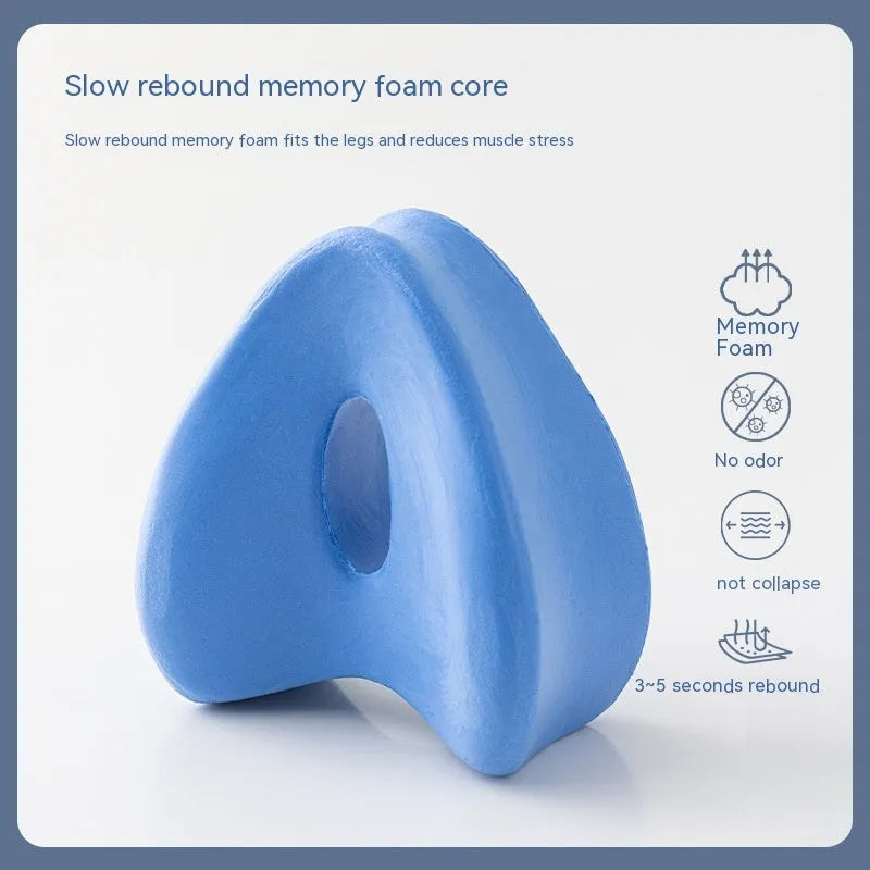 Heart-shaped dark blue memory foam leg pillow for adults on a bed
