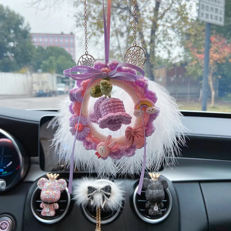 Handwoven wool bell orchid car pendant in green, hanging with dreamcatcher charm.