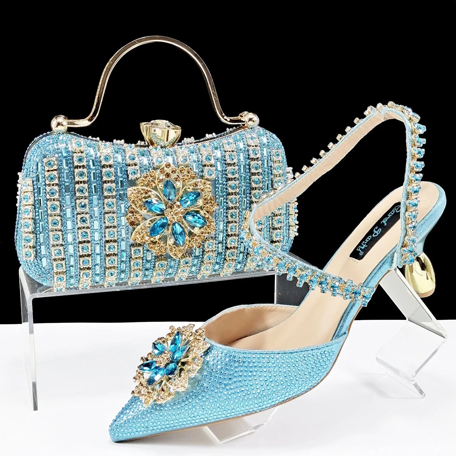 Women's black synthetic leather high-heel shoes with rhinestone ankle chain and matching hard clutch bag.