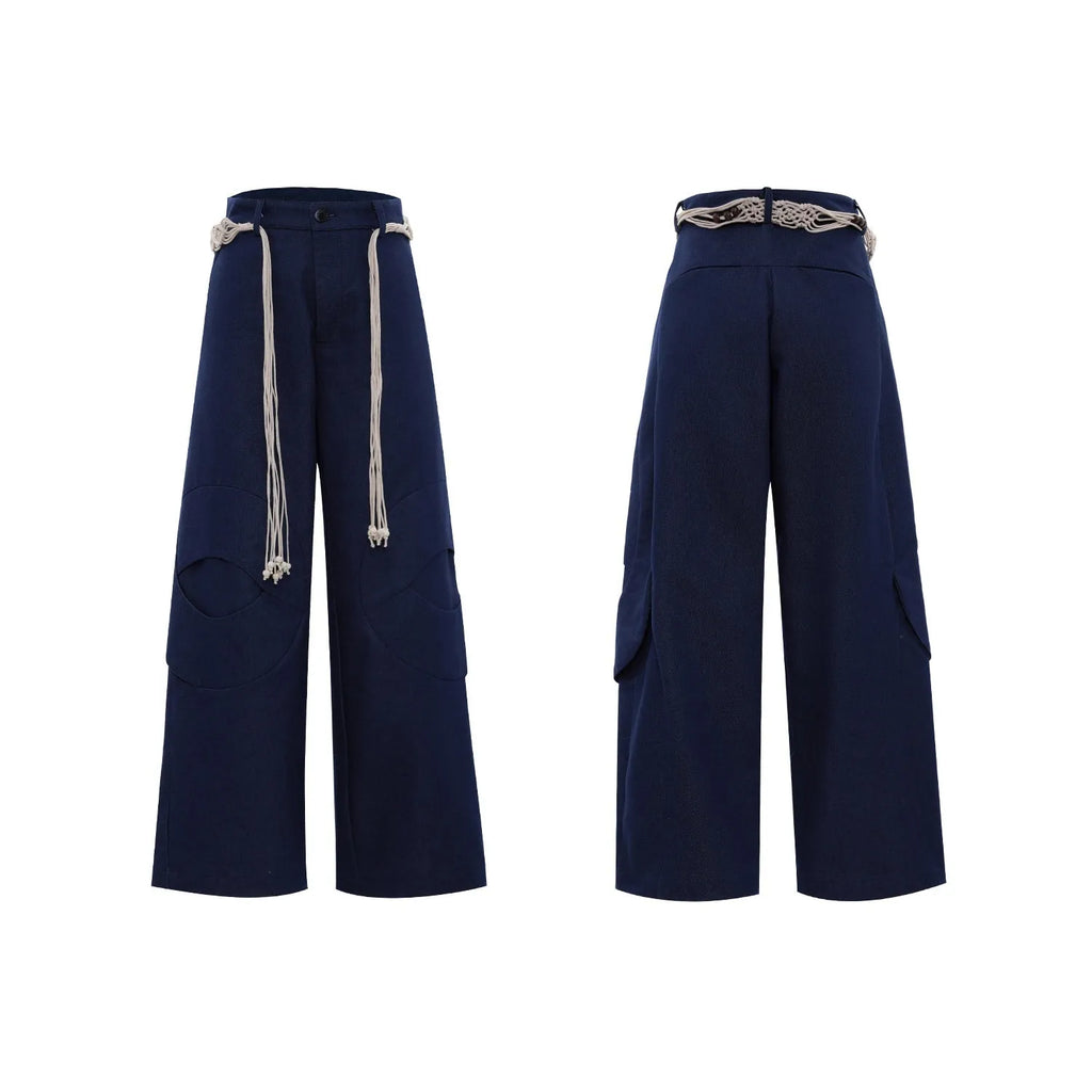 Men's dark blue straight-leg trousers showing heavy 3D cutting, belt stitching, and a front placket zipper.