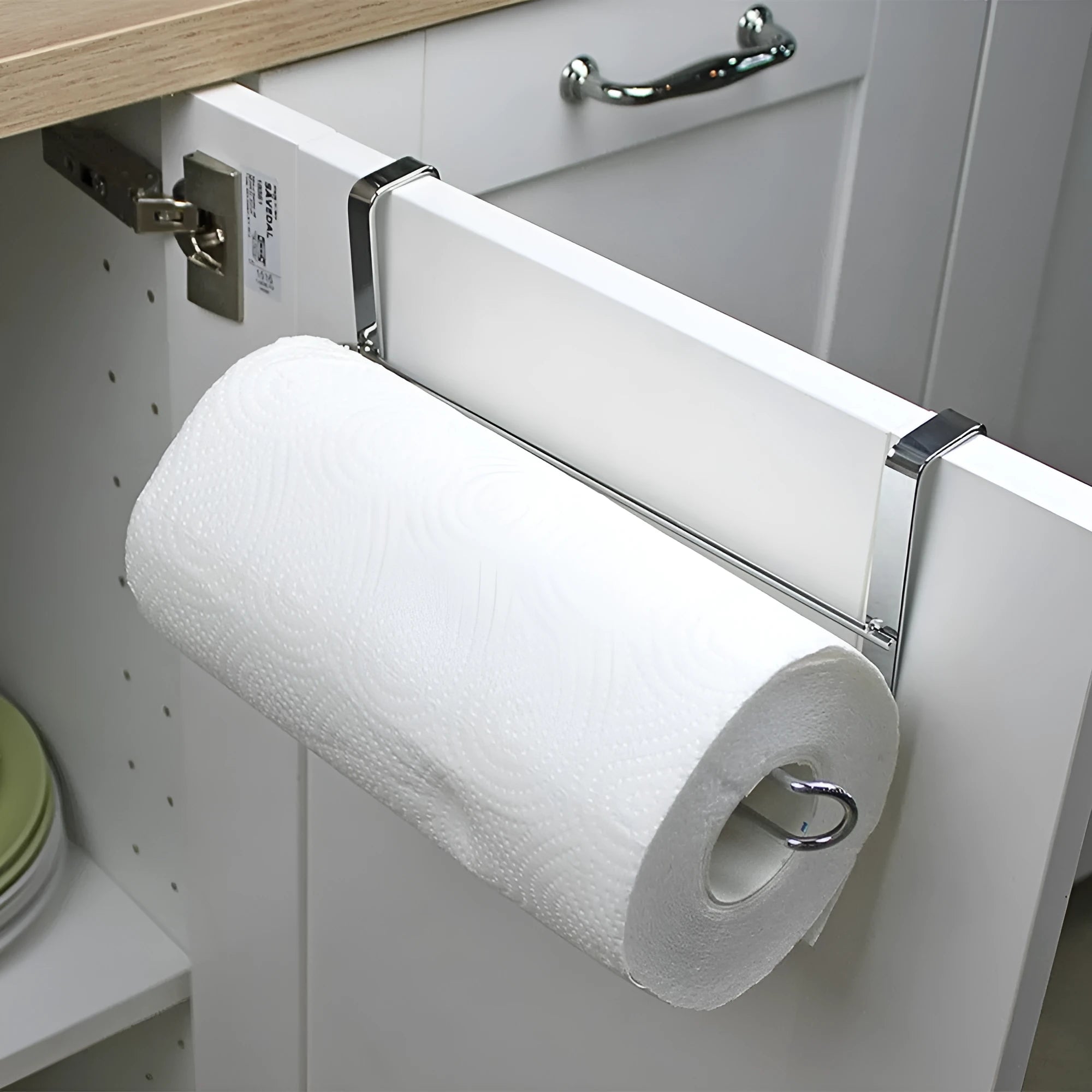 Silver stainless steel paper towel rack mounted on kitchen cabinet door back