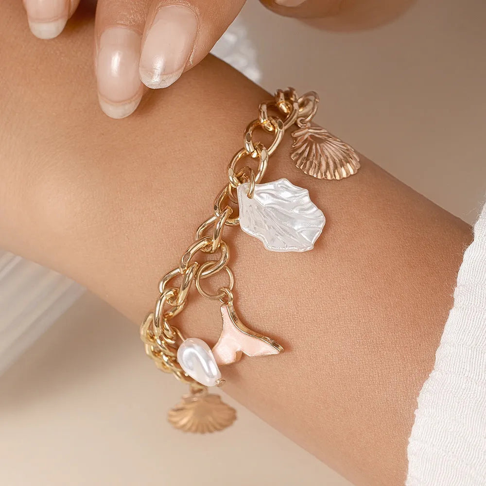 Women's white pearl alloy shell pearl mermaid tail bracelet on neutral background