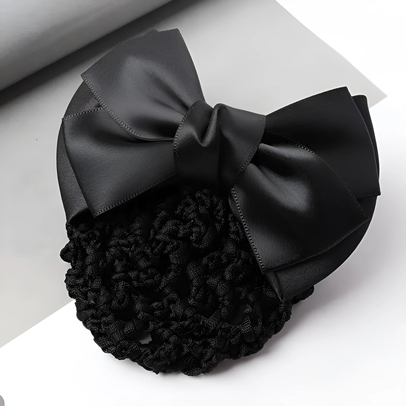 Professional hair clip with a black net pocket and a red flower bow ornament on a white background.