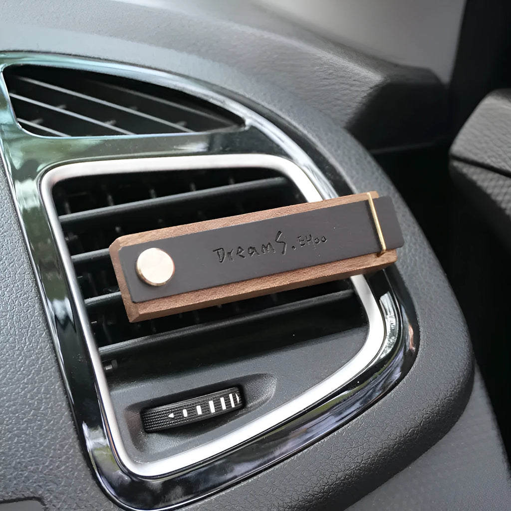 Customisable car perfume ornament diffuser with wood body and brass clip on a car air vent