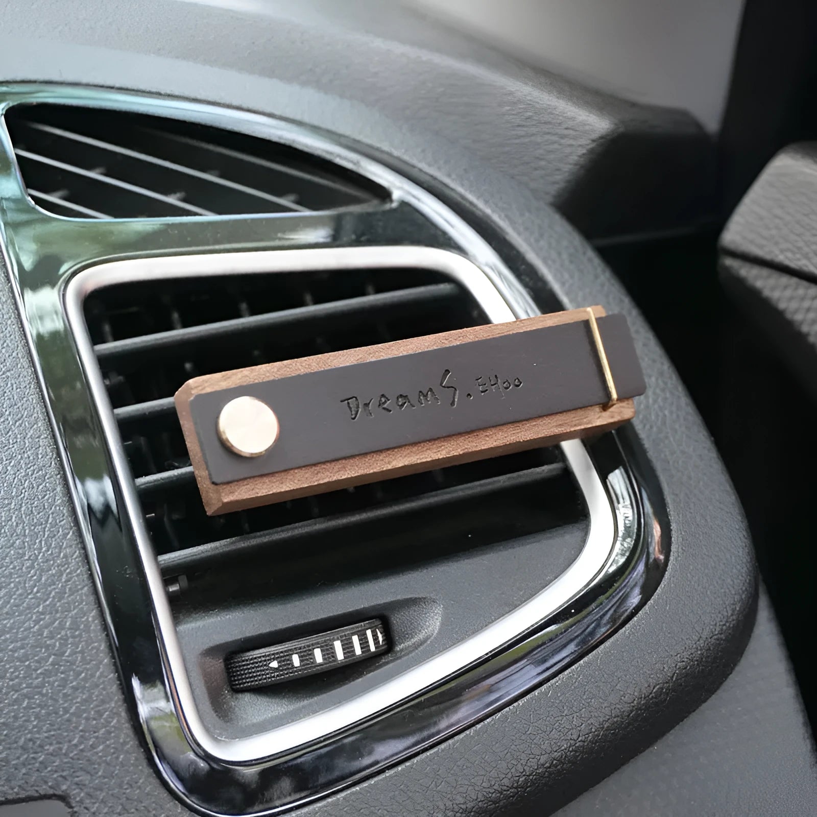 Customisable car perfume ornament diffuser with wood body and brass clip on a car air vent