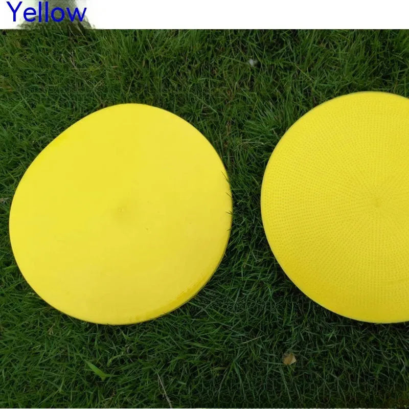 Yellow TPE football training target disc on grass, 23cm diameter flat landmark pad