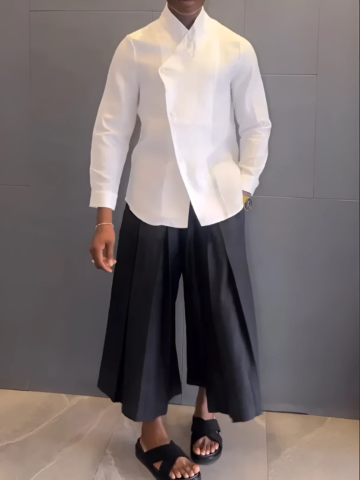 Women's white asymmetrical long sleeve shirt and black pleated trousers casual co-ordinates set on a hanger.