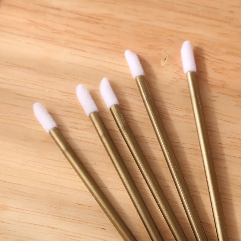 Pack of disposable lip brush applicators with flocked heads and black handles on a white background.