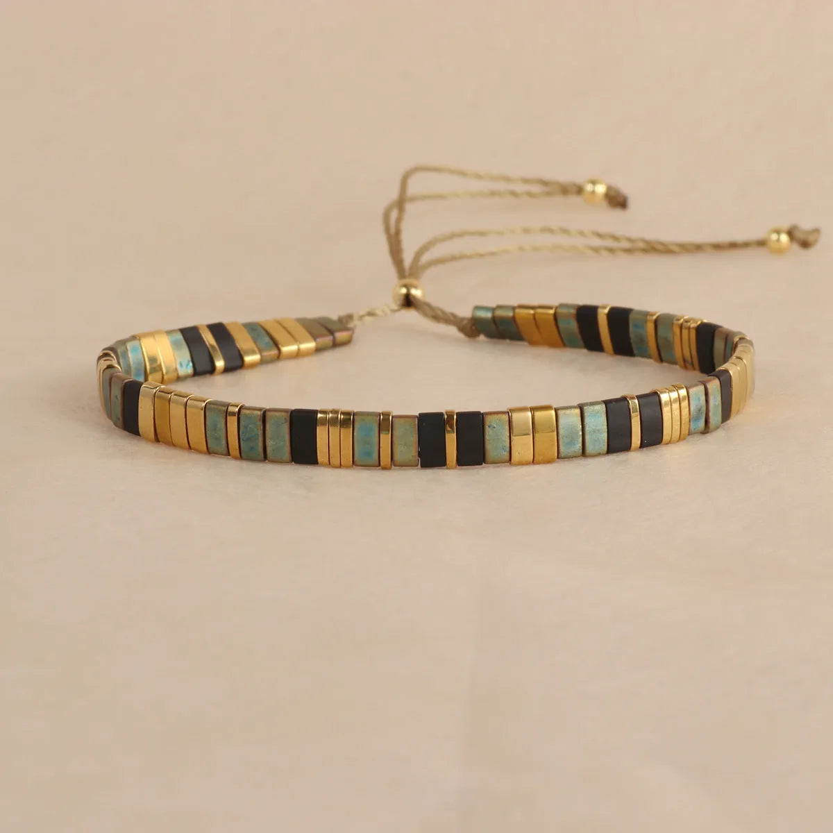 Adjustable pull beads bracelet with glass and coloured glaze beads in geometric and round shapes