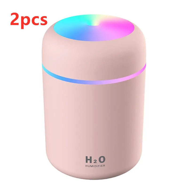 Pink USB portable humidifier with 300ml water tank on wooden desk surface