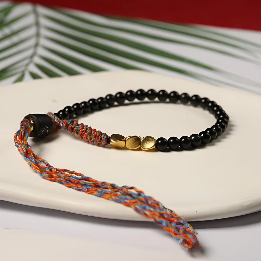 Hand-woven obsidian carrying strap bracelet showing textured weave and adjustable 15.5-16cm length