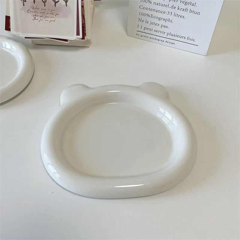 White porcelain round plate with chubby toot bear doodle pattern, shown as a plant saucer.