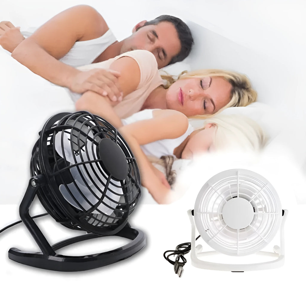 Compact black mini USB desk fan with adjustable tilt, placed next to a laptop.