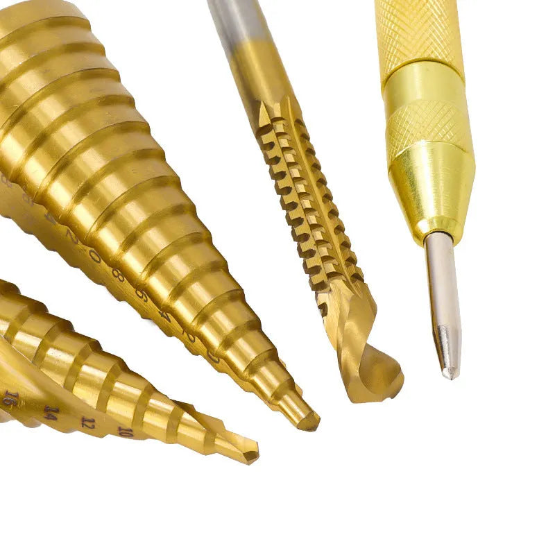 High speed steel cone step drill bits and a centre punch arranged on a workshop bench.