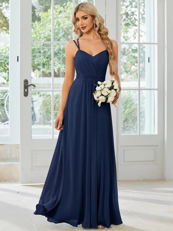Women's light green sleeveless dress with sling neckline and long pleated A-line skirt.