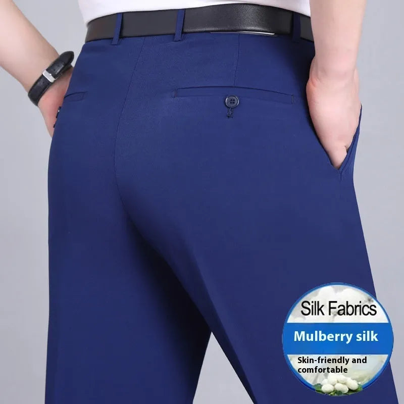 Man wearing dark blue straight-leg suit trousers with a high waist, made from a mulberry silk blend fabric.