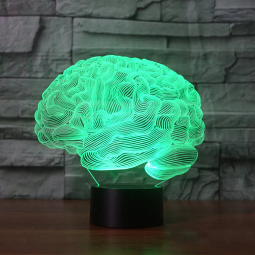 3D acrylic brain illusion LED desk lamp with remote control on a wooden table.