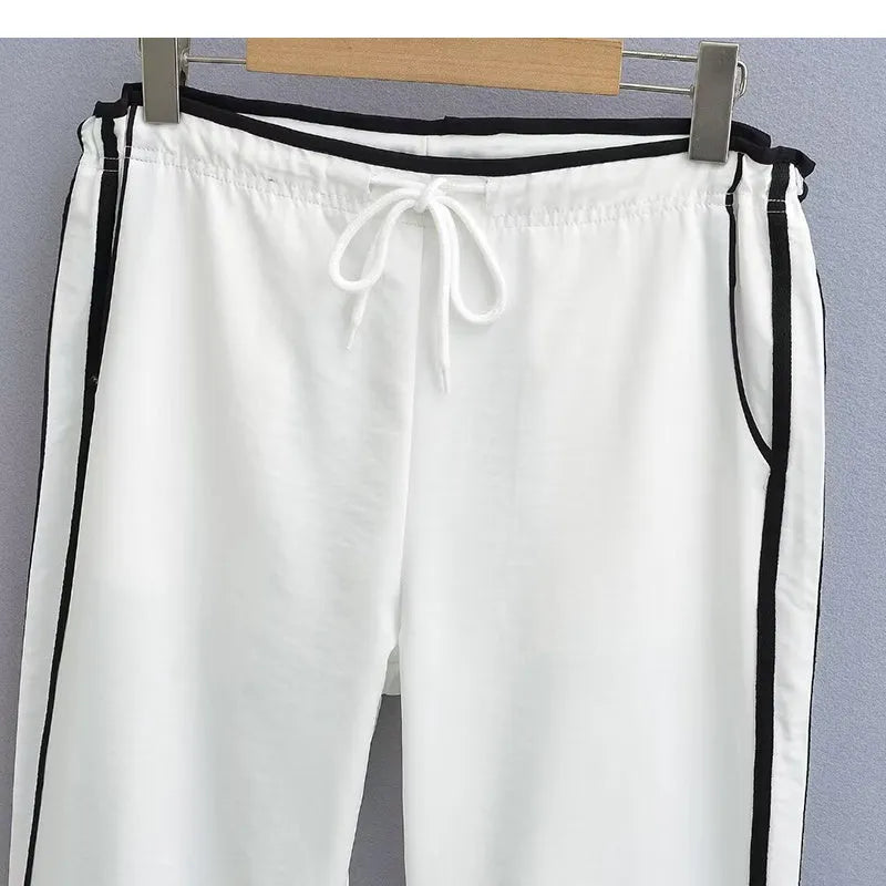 Women's navy blue loose straight-leg pants with white contrast ribbon parallel bars detail and low waist.